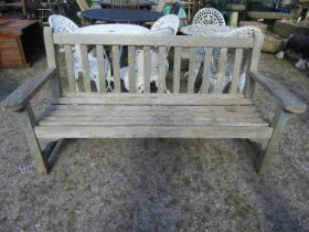 A weathered teak garden bench with slatted seat and back, with traces of painted finish, 162cm