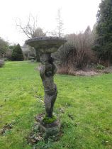 A weathered reconstituted bird bath, the column in the form of a boy, arms aloft, old repairs, 95 cm
