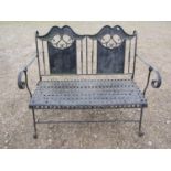 A decorative painted iron work folding two seat garden bench with lattice patterned seat, open