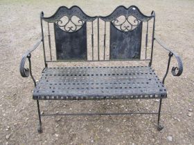 A decorative painted iron work folding two seat garden bench with lattice patterned seat, open