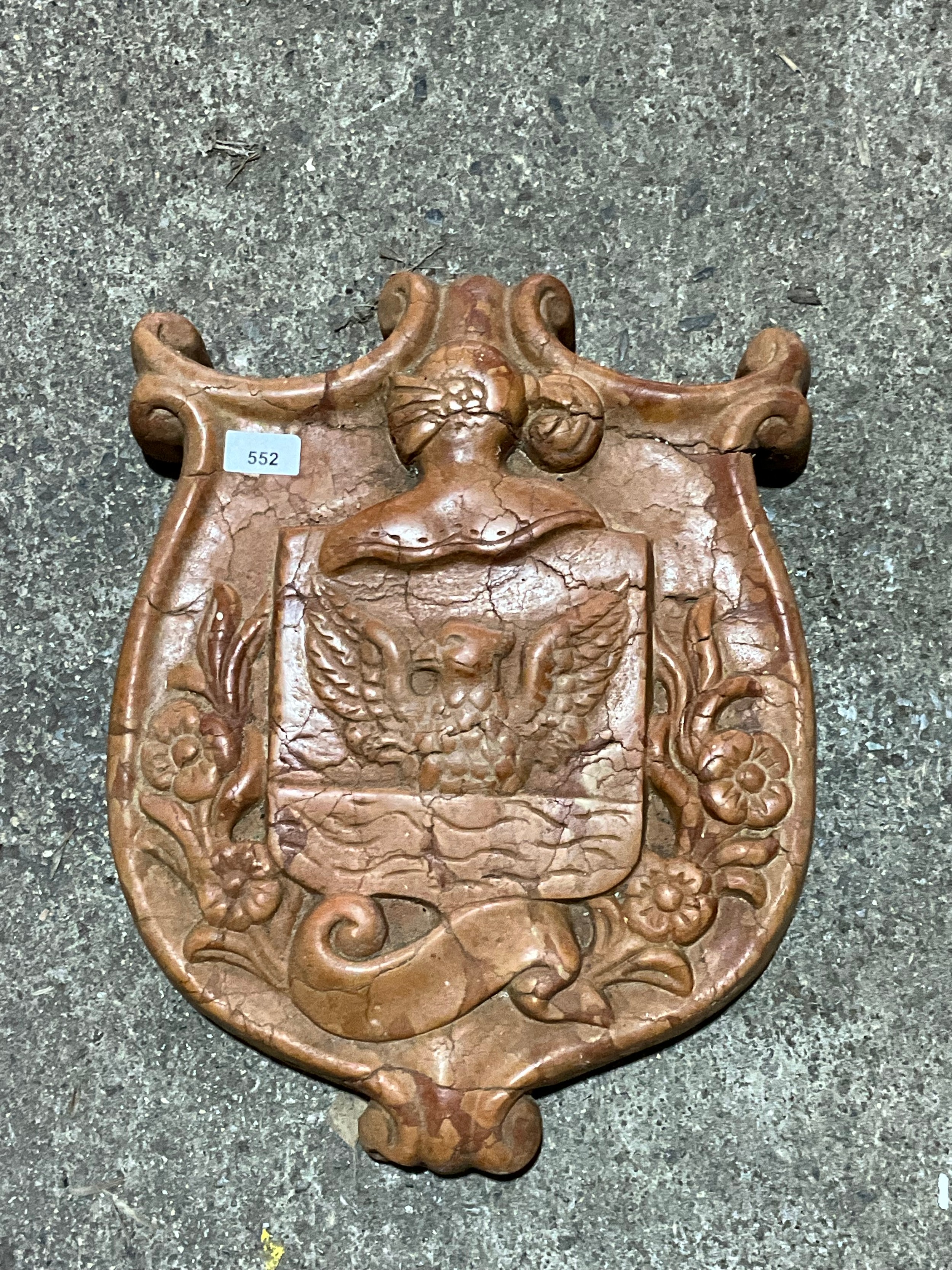 A decorative continental carved red marble armorial shield, 46 x 36cm