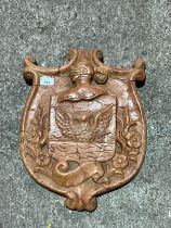 A decorative continental carved red marble armorial shield, 46 x 36cm