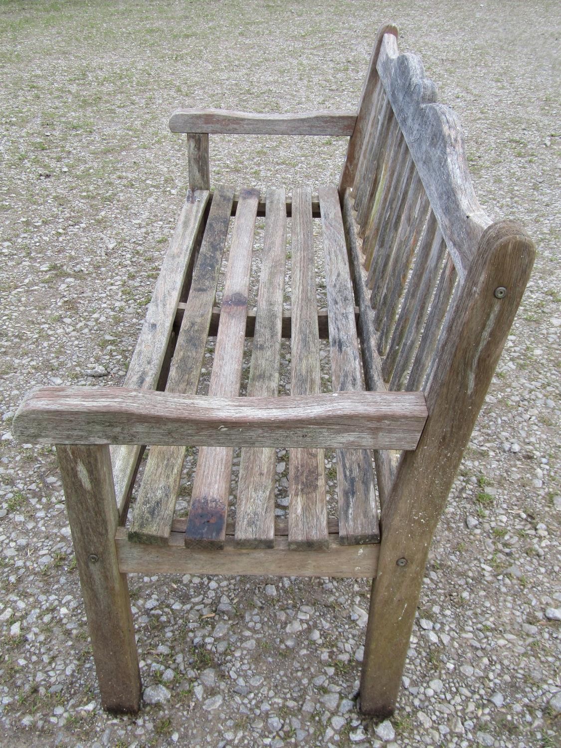 A Bridgman weathered teak three seat garden bench with slatted seat and back beneath a shaped rail - Image 2 of 3
