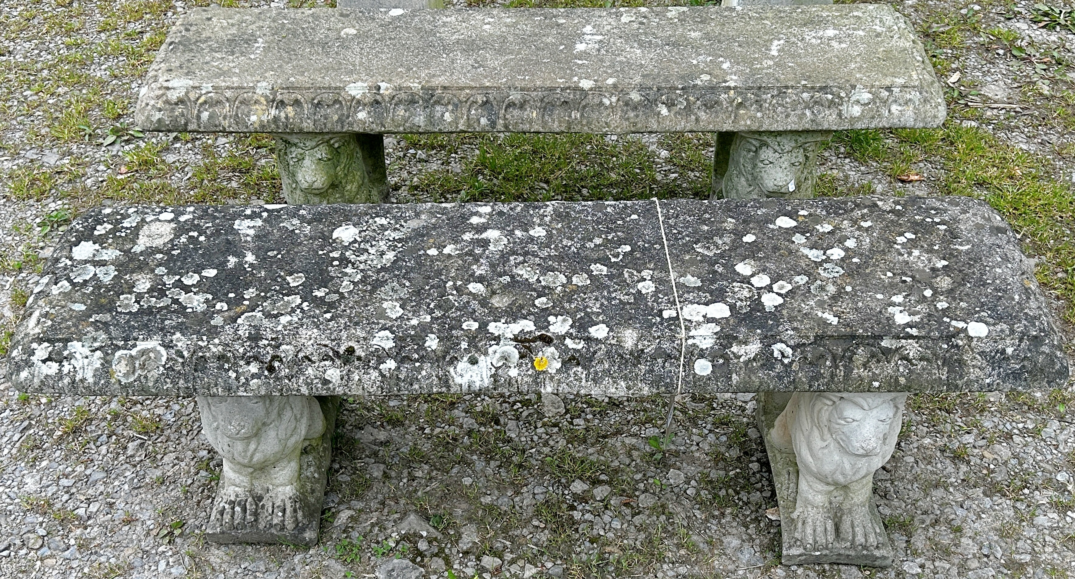 A pair of weathered cast composition stone three sectional garden benches with rectangular slab
