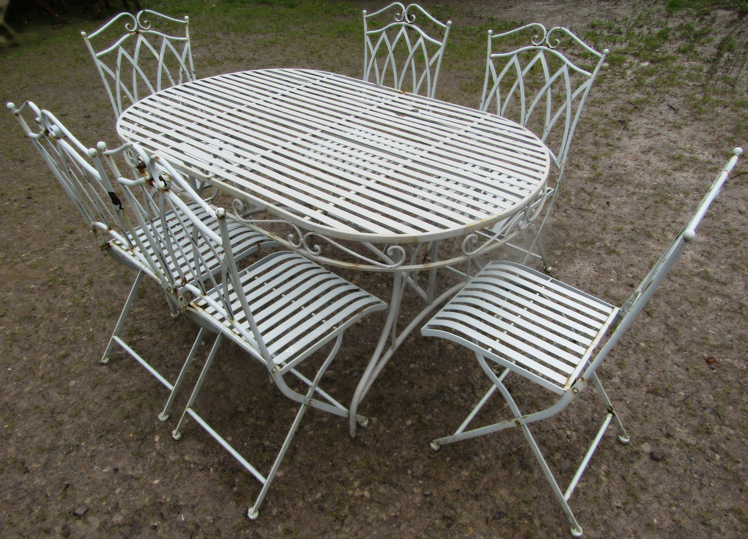 A light blue grey seven piece garden terrace set comprising table of oval form with strap work top