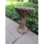 A painted and weathered cast composition stone bird bath in the form of a tree stump, 70 cm high