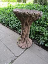 A painted and weathered cast composition stone bird bath in the form of a tree stump, 70 cm high