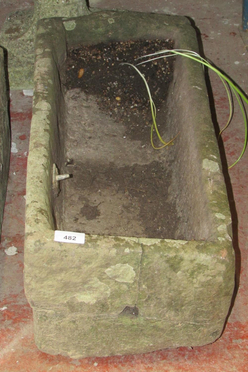 A small weathered natural carved stone planter/ trough of rectangular form with a drilled drainage