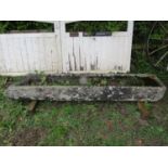 A long and narrow rectangular weathered natural carved stone trough with broken end 25 cm high x 222
