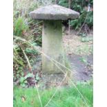 A weathered cast composition stone staddle stone with domed cap raised on a square tapered and