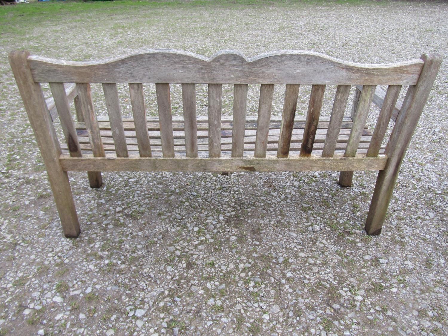 A Bridgman weathered teak three seat garden bench with slatted seat and back beneath a shaped rail - Image 3 of 3