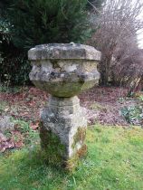 A weathered limestone urn and stand of octagonal form raised on a square cut plinth, 85 cm in height