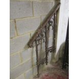 A 19th century ironwork step rail with open scroll detail and scrolled and moulded wooden hand rail,