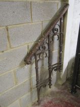 A 19th century ironwork step rail with open scroll detail and scrolled and moulded wooden hand rail,