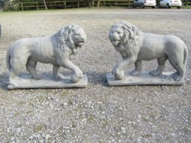 A pair of cast composition stone garden terrace/pier ornaments in the form of standing lions, 58