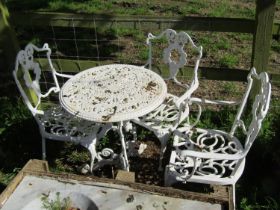 A small weathered cast iron terrace table with decorative pierced circular top raised on scrolled