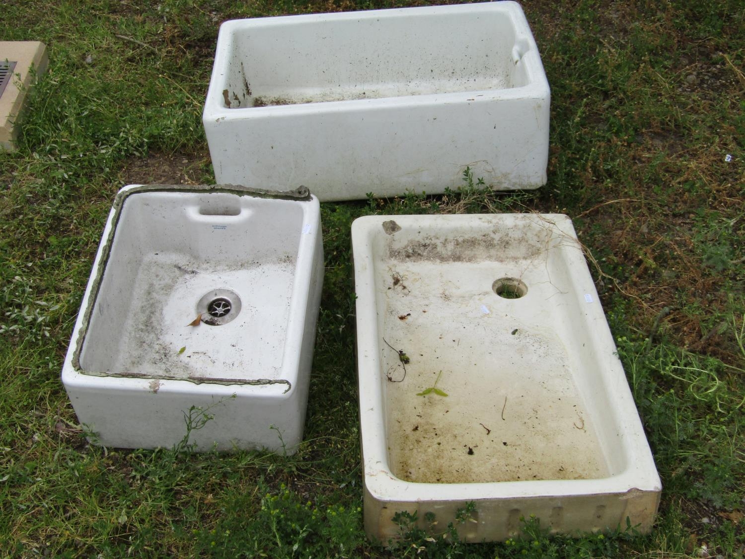 Three reclaimed white glazed butlers sinks of varying size and design, the largest 76 cm long x 50