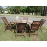 A stained and weathered hardwood garden suite comprising table with oval slatted top and single