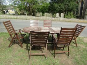A stained and weathered hardwood garden suite comprising table with oval slatted top and single