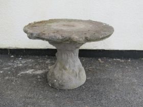 A weathered low two sectional novelty cast composition stone garden table in the form of a tree