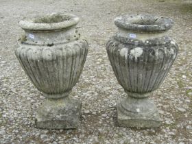 A pair of fluted weathered cast composition stone oviform urns / planters, 43cm high