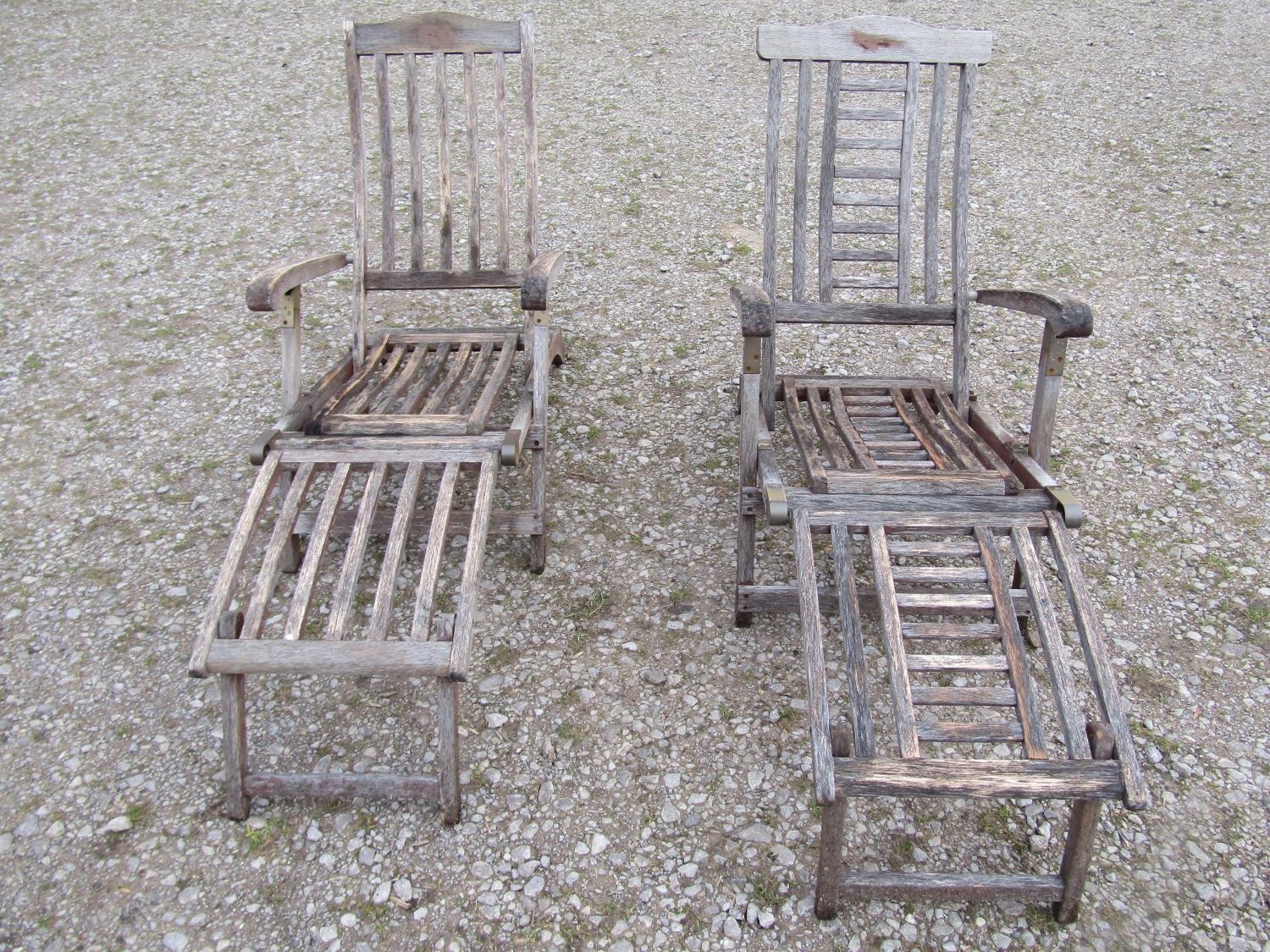 Two weathered teak folding steamer type chairs with slatted seats, backs and foot rests, with