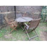 A weathered contemporary Teak folding garden table and four chairs