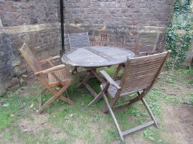 A weathered contemporary Teak folding garden table and four chairs