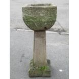 A weathered cast composition stone garden planter of square tapered and rounded form with floral