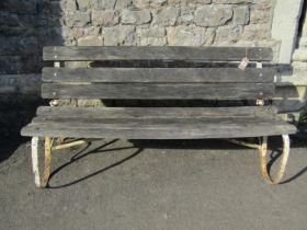 An old unusual garden bench with weathered timber slatted seat and back (able to fold) raised on