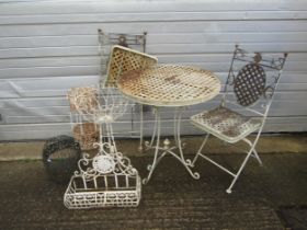 A heavy gauge weathered cream painted metal three piece garden terrace set with lattice detail,