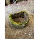 A weathered carved natural stone planter / trough of demilune form, with drainage hole to one