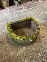 A weathered carved natural stone planter / trough of demilune form, with drainage hole to one