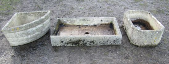 Three stone weathered cast composition garden troughs of varying size and design, the shallow