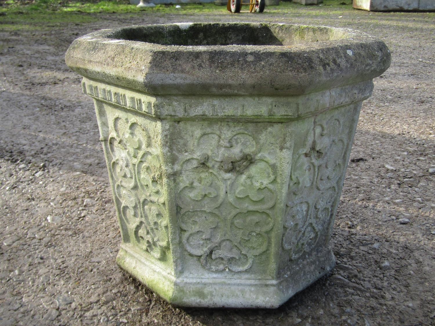 A weathered cast composition stone octagonal gothic style planter with repeating panels, 41 cm