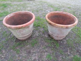 A pair of large weathered terracotta planters of circular tapered and simple ribbed form, 56 cm high