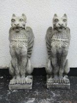 A pair of good quality cast composition stone pier ornaments in the form of seated lions mask