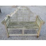 A weathered teak Lutyens style two seat garden bench, 136 cm wide