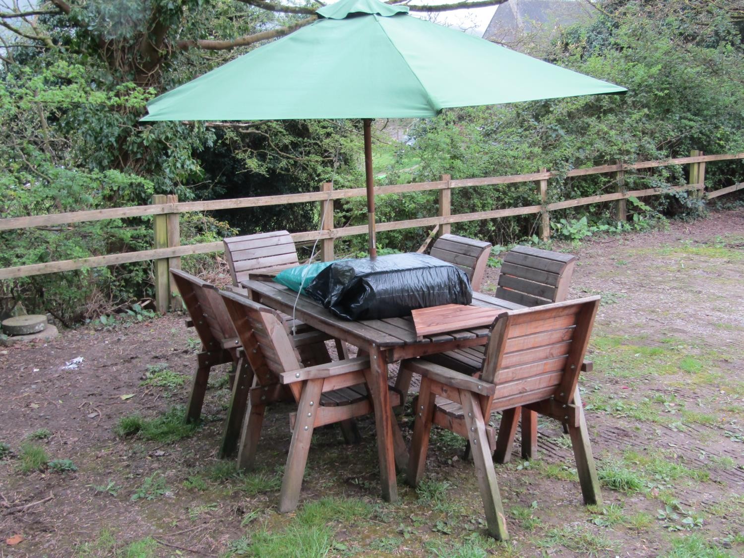 A contemporary weathered soft wood garden terrace suite comprising table with rectangular slatted