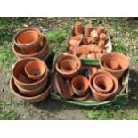 A large quantity of terracotta flower pots and planters of varying size and design to include glazed