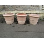 Three terracotta planters of circular tapered, ribbed form, stamped Deroma, 50cm diameter x 40cm