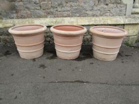 Three terracotta planters of circular tapered, ribbed form, stamped Deroma, 50cm diameter x 40cm