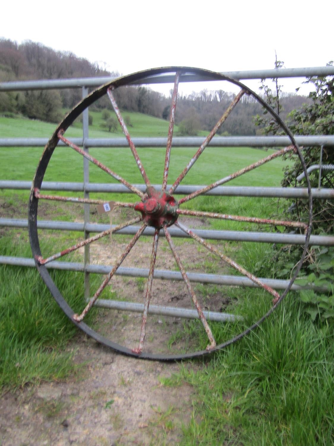 A large antique iron implement wheel with traces of layers of painted finish 122 cm (4ft diameter)