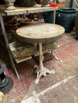 A Victorian cast iron table base with partially fluted column and stylised dolphin supports