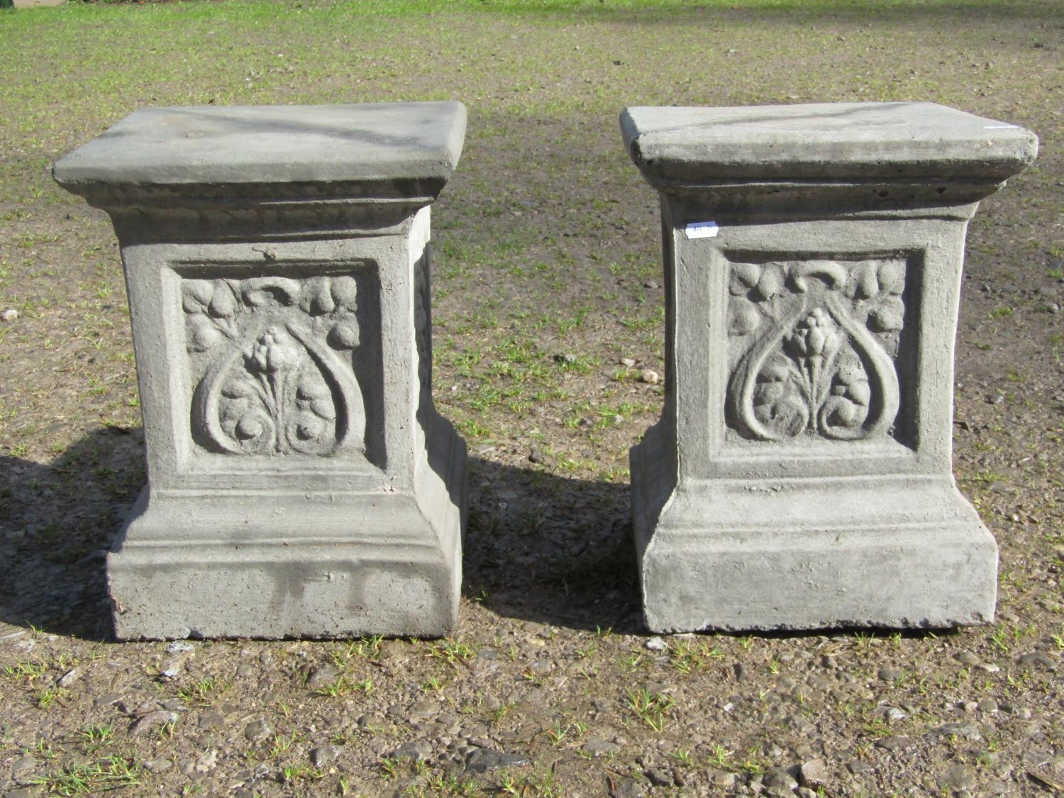 A pair of cast composition stone square cut and stepped pedestals, with repeating foliate panels,