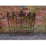 A heavy gauge iron gate with decorative open scroll work detail and spearhead finials, 121cm high