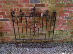 A heavy gauge iron gate with decorative open scroll work detail and spearhead finials, 121cm high