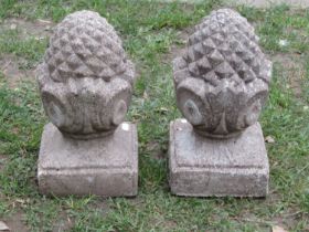 A pair of small weathered cast composition stone pier caps with pineapple finials, 32cm high x