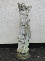 A painted and weathered cast composition stone garden statue in the form of a maiden with long