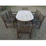 A contemporary Cotswold Collection weathered teak garden table with oval slatted top raised on